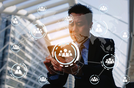 business man wearing modern black suit using mobile smart phone and briefcase with virtual innovation, network connection interface diagram, technology communication, internet and financial conceptの写真素材
