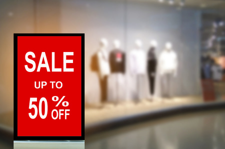 big sale 50% mock up advertise billboard or advertising light box with blurred image of popular fashion clothes shop showcase in shopping mall, commercial, marketing and advertisement conceptの写真素材