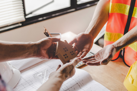 contractor transfer house model to realtor for client customer after signing contract for buying house in estate agent office, investment, home loan contract, insurance, buy and sell house conceptの写真素材