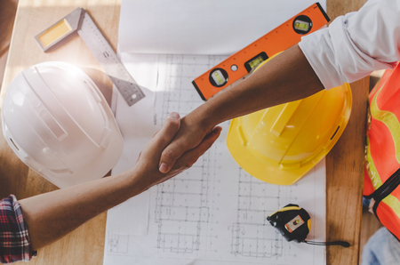 top view construction worker team contractor hand shake after finishing up business meeting to greeting start up project contract in construction site building, teamwork, partnership, industry conceptの写真素材