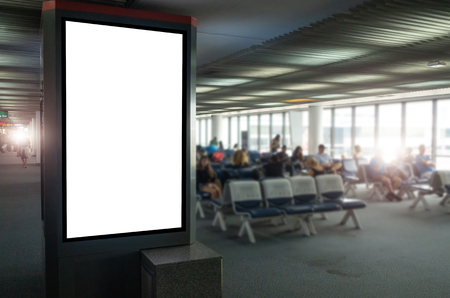 mock up of vertical blank advertising billboard or light box showcase with people waiting at airport, copy space for your text message or media content, advertisement, commercial and marketing conceptの写真素材