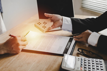 real estate broker manager giving wooden house model to customer after signing contract for buying house in estate agent office, investment, home loan contract, selling house and realtor conceptの写真素材