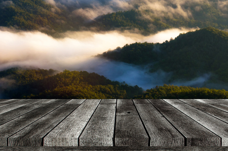 empty wooden board, table or modern wooden terrace with soft focus image of beautiful view sunrise of mountain with morning mist in Thailand, travel, landscape and nature concept with copy spaceの写真素材