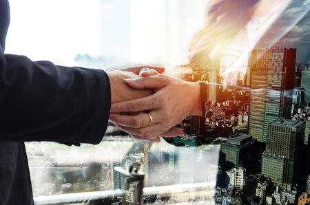 Partnership. double exposure image of investor business woman handshake with partner for successful meeting deal with during sunrise and cityscape background, investment, partnership, teamwork conceptの写真素材