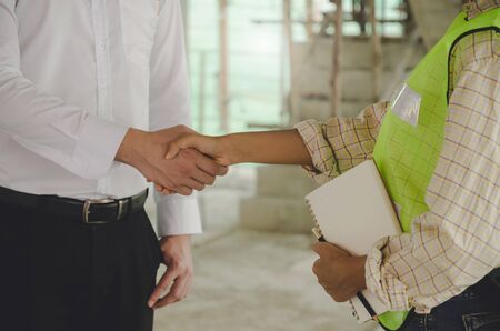 construction worker team hands shaking after consultation meeting to greeting start up plan new project contract in office center at construction site, teamwork, partnership and contractor conceptの写真素材