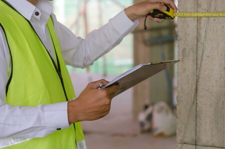 Construction. young foreman builder, engineer or inspector checking and inspecting with clipboard...