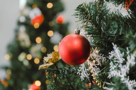Merry Christmas. red color decorated ball hanging on christmas tree with bokeh light background, holiday family, happy new year and merry christmas festival concept, vintage color tone effectの写真素材
