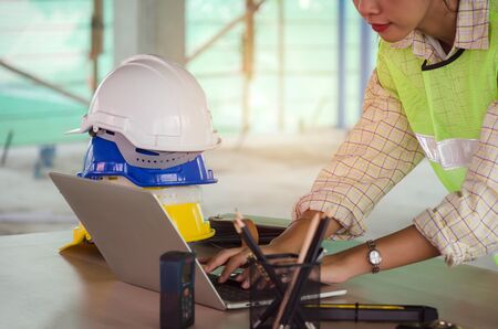 professional architect, engineer or interior hands working with laptop and safety helmet on workplace desk in office center at construction site, contractor, construction and engineering conceptの写真素材
