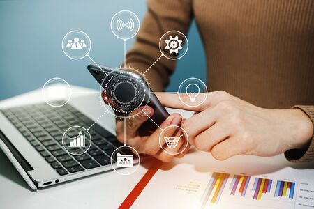 woman hand working about financial on mobile phone with virtual digital icon, laptop computer and...