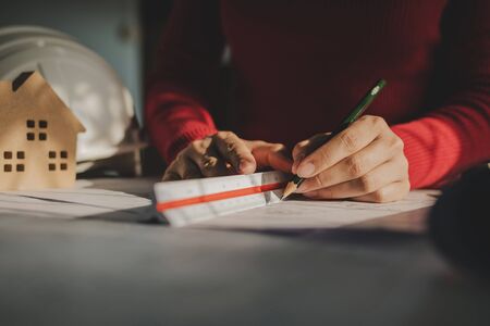 professional architect or interior designer hands drawing with pencil and mock up blueprint on...