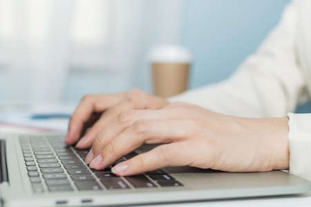 attractive businesswoman in white suit hand working about finance business on digital laptop computer on desk in meeting room at home office, digital online marketing and financial business conceptの写真素材
