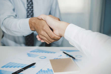 Partnership. two business man investor handshake deal with partner after finishing up business meeting on desk in meeting room office, financial, teamwork, job interview, contract agreement conceptの写真素材