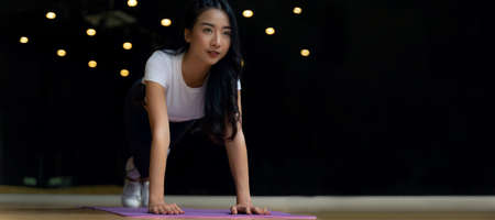 Panoramic banner. athletic young asian pretty sporty woman slim body doing plank exercising on yoga mat in fitness gym for good health, bodybuilder, exercise fitness, workout, sport training conceptの写真素材