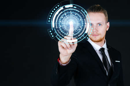 smart caucasian business man in black suit hand touching virtual screen graphic diagram on dark background, internet security, innovation, network connection, investment and digital technology conceptの写真素材