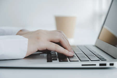 business people hand working on laptop computer on desk at home office, work from home, searching web, social network, online, business strategy, finance, investment and digital technology conceptの写真素材