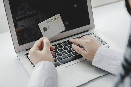 woman hand entering password code on laptop computer paying bill with credit card on desk at home office, internet, digital marketing, shopping online, online payment and digital technology conceptの写真素材