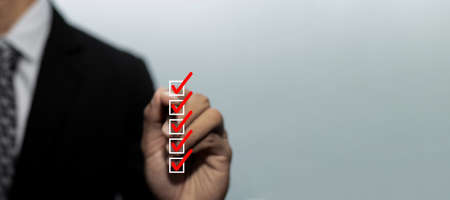 Panoramic wide banner. business man investor hand checking mark on checklist box with pen to review...