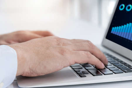 hand of business people working on laptop computer on desk at home office, work from home, searching web, social network, online, business strategy, finance, investment and digital technology conceptの写真素材