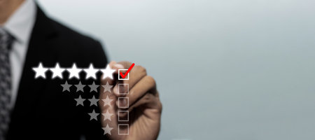 wide banner copy space. businessman hand checking mark five star rating on checklist box with pen to review good rating, digital marketing, good experience, customer feedback, satisfaction conceptの写真素材