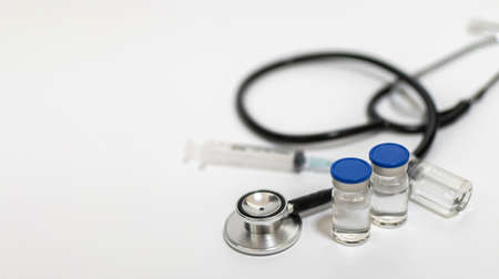 wide banner. coronavirus vaccine bottle, stethoscope and medical equipment on white background, virus prevention, vaccination, medical technology, research laboratory, covid-19 vaccine conceptの写真素材
