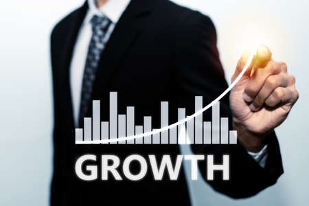 businessman investor hand pointing with pen on virtual graphic graph chart screen on white...