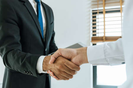 Deal. business people handshake after business signing contract document on desk in meeting room at company office, partnership, job interview, investor, negotiation, partnership and teamwork conceptの写真素材