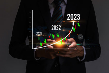 business man hand using mobile tablet working business financial with virtual graphic graph chart...