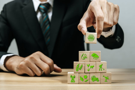 Smart Farming. business man investor hand arranging wooden block with agricultural icon on desk, business management, team leader, smart farm, agricultural industry, market trend, start up conceptの写真素材