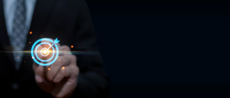 business man investor hand pointing on virtual target icon diagram on dark background, business finance analysis, digital marketing, company strategy, business development, investment plan conceptの写真素材
