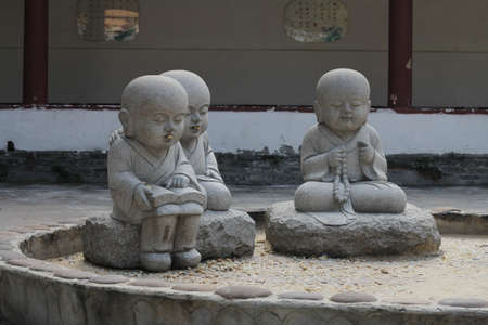 Little monks with peanuts in their mouths in a Chinese Buddhist temple の写真素材