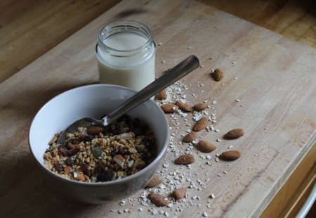 Home made granola in a bowl with oat milk and almondsの写真素材