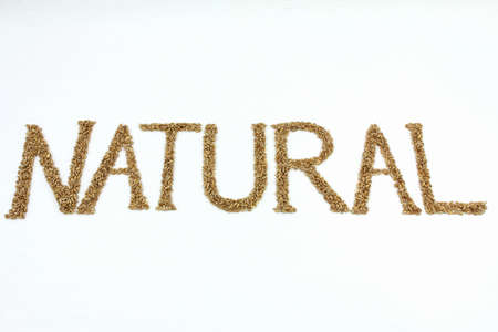 Natural written with wheat kernels on white backgroundの写真素材