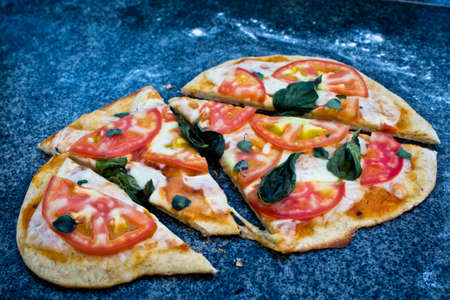 Homemade margherita pizza with basil and sliced ??fresh oreganoの写真素材