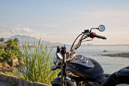 classic style custom motorcycle sunlit sea sky and landscapeの写真素材