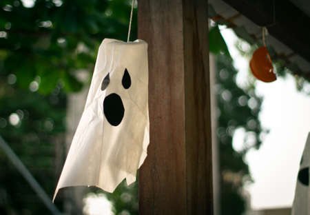 white ghost Halloween decoration hanging outdoors at daytimeの写真素材