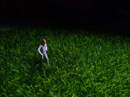 Running Mini Figure man in the night at fresg green grassの写真素材