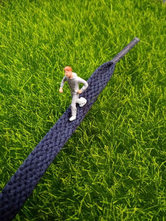 photo running mini figure man toy at shoe laces,