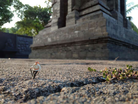 Mini Figure adventurer Walking at stone road passing by big Templeの写真素材