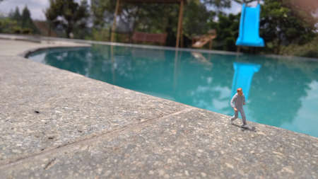 Running Mini Figure man in the morning, at side of swimming pool