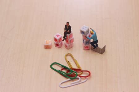 illustration for raising earn related issue, information, article at wooden table, mini figure toy...