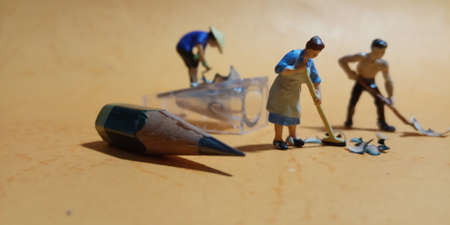 2 man and 1 woman cleaning trash from pencil sharpener with negative spaceの写真素材