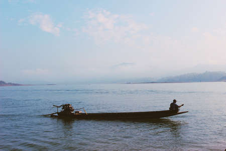 Man sitting alone on top boat and boating.の写真素材