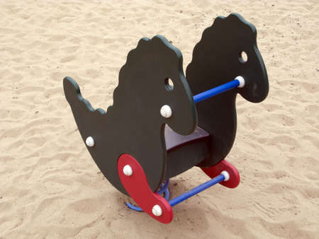 Rocking horse in sand outdoorsの写真素材