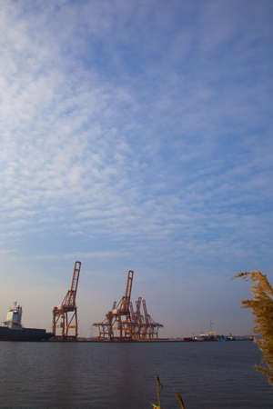 Amsterdam, The Netherlands, 20 February 2011 - Skyline at harbor with blue sky, cranes and shipのeditorial素材
