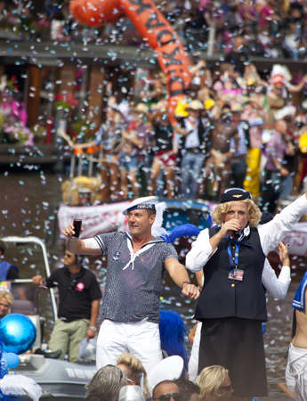 AMSTERDAM - AUGUST 6, 2011: Dutch celebrities Gerard Joling and Gordon greets from a boat at Canal...