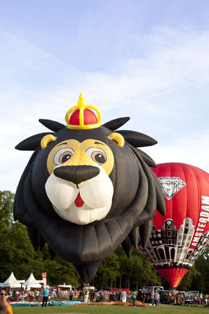 BARNEVELD, THE NETHERLANDS - 17 AUGUST 2012: Colorful lion and red air balloons taking off at international balloon festival Ballonfiesta in Barneveld on August 17 in Barneveld, The Netherlands のeditorial素材
