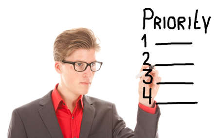 Young man writing priority items isolated on white backgroundの写真素材
