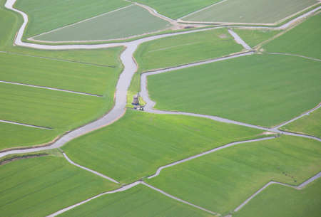 Green landscape with water and windmill from above, Netherlands