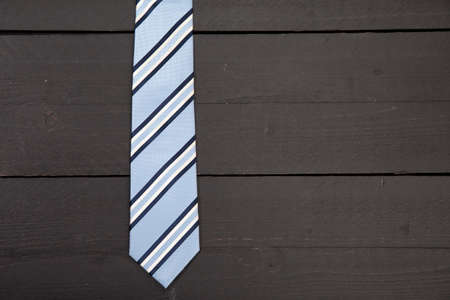 Striped business tie on dark wooden backgroundの写真素材