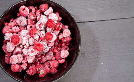 Frozen raspberries on dark wooden backgroundの写真素材